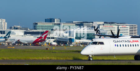 Détail de Sydney Kingsford Smith) (Aéroport de Sydney, en Australie, à l'égard du Terminal International à l'ouest de l'aéroport. Sur la photo : un avions à turbopropulseurs QantasLink à taxying la 16L/34R parallèle nord sud piste. Banque D'Images