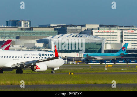 Détail de Sydney Kingsford Smith) (Aéroport de Sydney, en Australie, à l'égard du Terminal International à l'ouest de l'aéroport. Sur la photo : un Qantas Airways Boeing 737-800 taxying vers le terminal de l'aéroport. Banque D'Images