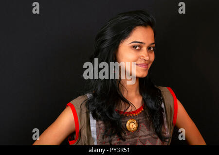 Happy young woman smiling sur fond noir, Pune, Inde. Banque D'Images