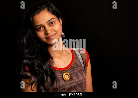 Happy young woman smiling sur fond noir, Pune, Inde. Banque D'Images