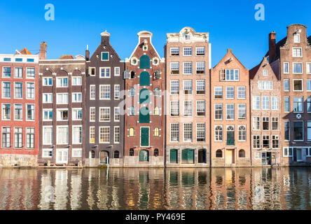 Maisons d'Amsterdam Damrak sur un canal partiellement remplies au dancing maisons avec l'architecture néerlandaise par le canal Amsterdam Hollande Pays-bas eu Europe Banque D'Images