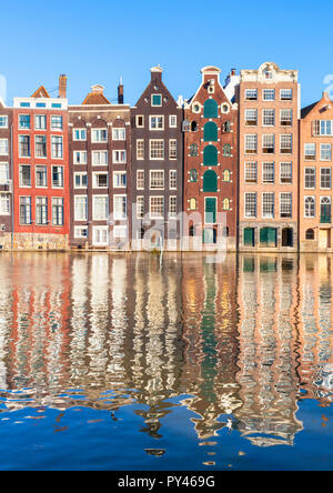 Maisons d'Amsterdam Damrak sur un canal partiellement remplies au dancing maisons avec l'architecture néerlandaise par le canal Amsterdam Hollande Pays-bas eu Europe Banque D'Images