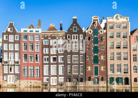 Maisons d'Amsterdam Damrak sur un canal partiellement remplies au dancing maisons avec l'architecture néerlandaise par le canal Amsterdam Hollande Pays-bas eu Europe Banque D'Images