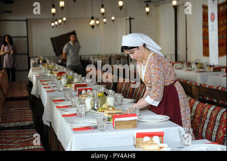 Au restaurant Tatar Tatar : serveuse en costume national mettant la table. Le 8 septembre 2018. Kiev, Ukraine Banque D'Images