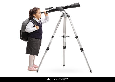 Tourné sur toute la longueur d'une écolière en uniforme à la recherche à travers un télescope isolé sur fond blanc Banque D'Images