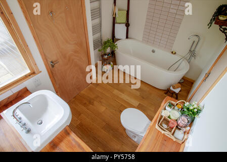 Un portrait d'une salle de bains moderne de l'intérieur, des bougies colorées peut être vu sur une planche en bois. Banque D'Images