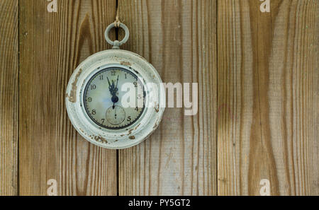 Vieille horloge indique cinq à douze sur fond de bois Banque D'Images