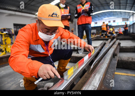 Liupanshui, province du Guizhou en Chine. 25 octobre, 2018. Un participant vérifie la qualité lors d'un concours de compétences brunissage ferroviaire, Liupanshui dans la province du Guizhou en Chine du sud-ouest, le 25 octobre 2018. Un total de 30 travailleurs des chemins de fer ont participé à ce concours. Credit : Tao Liang/Xinhua/Alamy Live News Banque D'Images