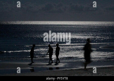 L'île de Boracay, Philippines. 26Th Oct, 2018. Les gens sont en silhouette par la lune, réflexions sur l'eau le long de la plage quelques heures avant la réouverture de l'île de Boracay, Philippines, le 26 octobre 2018. La célèbre île de Boracay a rouvert ses plages et les eaux pour les touristes au milieu de l'apparat et pompe le vendredi après six mois de réadaptation et de nettoyage. Credit : Rouelle Umali/Xinhua/Alamy Live News Banque D'Images