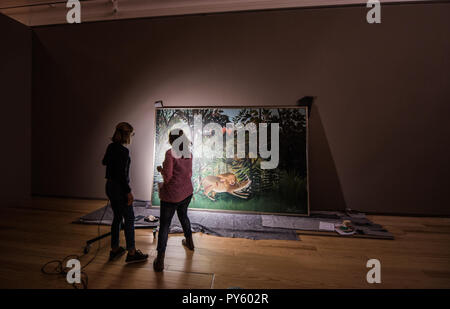 Francfort-sur-Main, Allemagne. 26Th Oct, 2018. Deux restaurateurs d'examiner le travail d'art 'Le lion affamé se jette sur l'antilope" (Henri Rousseau, 1898-1905). Avec l'exposition 'Wildnis' (1 novembre 2018 - 3 février 2019), la Schirn Kunsthalle de Francfort se montrant diverses oeuvres d'art sur ce thème. Crédit : Andreas Arnold/dpa/Alamy Live News Banque D'Images