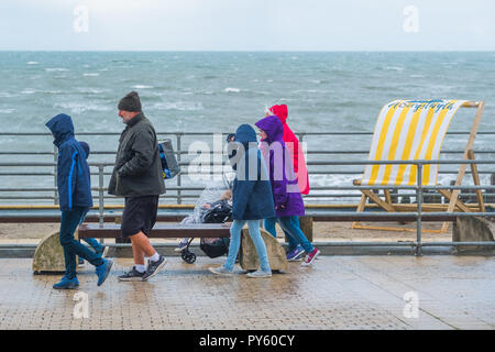 Pays de Galles Aberystwyth UK, vendredi 26 octobre 2018. Météo France : une famille d'agréables promenades le long de la promenade comme extrêmement froid vent du nord soufflent au-dessus de Aberystwyth, sur la côte ouest de la Baie de Cardigan au Pays de Galles que le temps tourne décidément à l'hiver crédit photo Keith Morris / Alamy Live News Banque D'Images