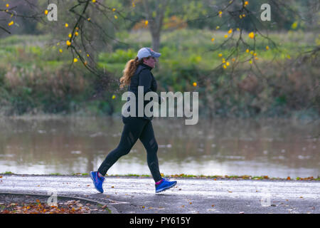 Joggeurs au parc Avenham, bordé par le Ribble, rivière lente. Les routes du réseau 6 et 62 avec des avenues bordées d'arbres traversent le parc et il y a des kilomètres de sentiers de course bien garnis et de jogging au bord de la rivière, fitness, coureur, exercice, sport, santé, style de vie, entraînement, athlète, course, forme, personnes, entraînement, actif, jeune, jogging, femme, femme, personne, athlétique, routes en plein air le long des rives de la rivière. Banque D'Images