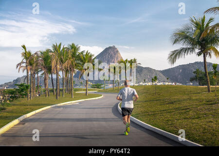 Homme qui court à la Marina da Gloria voie et mont du Pain de sucre sur l'arrière-plan - Rio de Janeiro, Brésil Banque D'Images