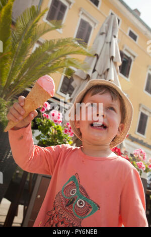 White baby girl licking manger une glace sur une chaude journée ensoleillée en Croatie en vacances. Banque D'Images