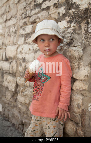 White baby girl licking manger une glace sur une chaude journée ensoleillée en Croatie en vacances. Banque D'Images