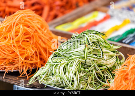 Libre de tas de beaucoup de courgette râpée, la carotte et les nouilles de concombre préparation cuisson brute renforts spiralés dans l'air extérieur d'aliments sains, marché de la rue oran Banque D'Images