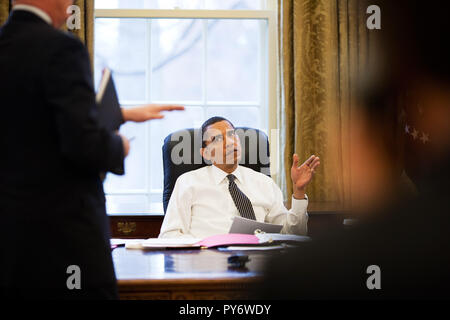 Le président Barack Obama est informé avant de faire des appels téléphoniques avec les dirigeants étrangers dans le bureau ovale 1/26/09. Photo Officiel de la Maison Blanche par Pete Souza Banque D'Images