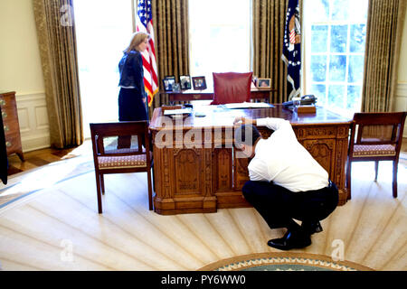 Le président Barack Obama examine le Resolute Desk le 3 mars 2009, lors de la visite avec Caroline Kennedy Schlossberg, dans le bureau ovale. Dans une célèbre photographie, son frère John F. Kennedy Jr., jeta à travers le panneau du FDR, tandis que son père, le président Kennedy a travaillé. Photo Officiel de la Maison Blanche par Pete Souza Banque D'Images