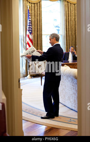 Chef de Cabinet de la Maison Blanche Rahm Emanuel ressemble à un journal dans le bureau ovale, comme le président Barack Obama parle au téléphone le 4 avril 2009. Photo Officiel de la Maison Blanche par Pete Souza Banque D'Images