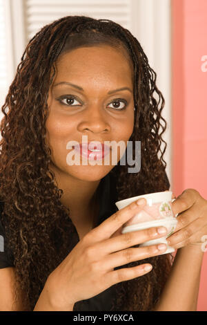 Pretty Young Woman Enjoying matin sa boisson chaude, USA Banque D'Images