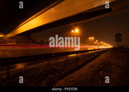 L'autoroute avec passerelle pour piétons dans la nuit Banque D'Images