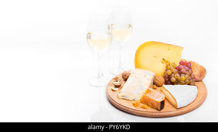 Plateau de fromage avec des raisins et du vin blanc isolé sur fond blanc. Variété de fromages mous et durs Banque D'Images
