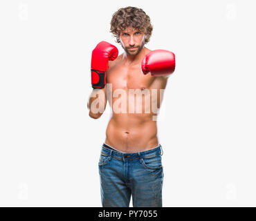 Handsome young man wearing boxing gloves boxer sur fond isolé avec expression grave sur le visage. Simple et naturelle à la recherche de l'appareil photo. Banque D'Images