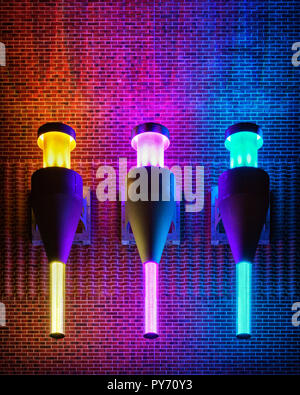 Trois lampes colorées sur un fond de pierre dans la nuit. Banque D'Images