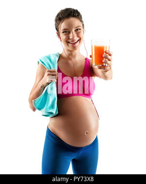 Temps de repos. Vêtements de femme enceinte en tenant une serviette et verre de jus d'orange isolé sur fond blanc. Concept de vie sain Banque D'Images