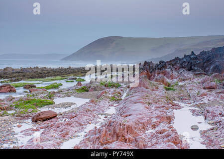 Photographie de paysage.La marée basse et la brise sur la pittoresque plage rocheuse avant le lever du soleil près de Tenby, Pembrokeshire, Pays de Galles du Sud,UK.longue exposition. Banque D'Images