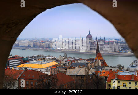 Vue sur le Parlement de Budapest, le Danube et des maisons voisines par une journée d'hiver à travers une arche Banque D'Images