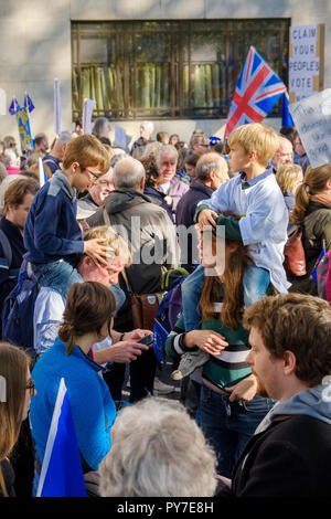 Deux jeunes garçons monter sur les épaules de l'homme et de la femme dans la foule marchant vers le bas de Park Lane. Un drapeau de l'union (Union Jack) et un signe à lire 'ce que n' Banque D'Images