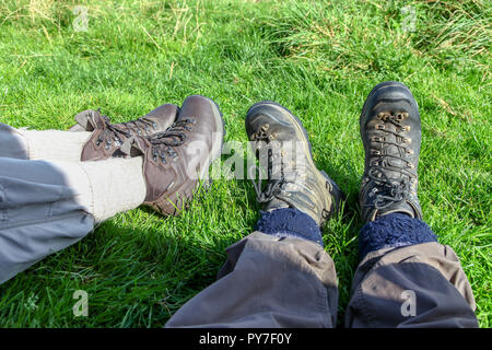 Un homme et une femme portant des chaussures de marche en position couchée sur l'herbe Banque D'Images