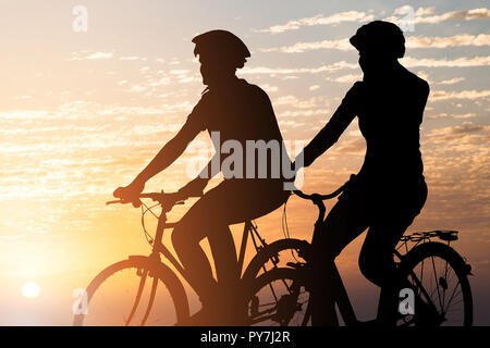 Silhouette d'un couple au coucher du soleil Banque D'Images