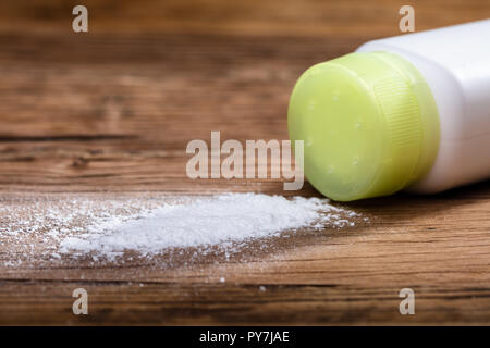 Close-up du produit répandu de la poudre de talc sur le bureau en bois Banque D'Images