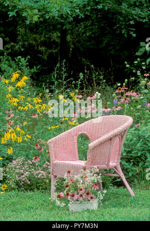 Wicker chair rose unique dans l'herbe avec des fleurs sauvages en fleurs, Missouri, États-Unis Banque D'Images
