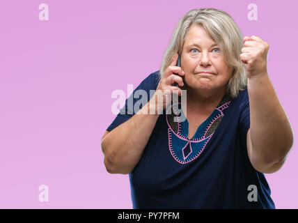 Grande taille Senior caucasian Woman talking on the phone sur fond isolé contrarié et frustré de crier avec colère, fou et hurlant de rais Banque D'Images