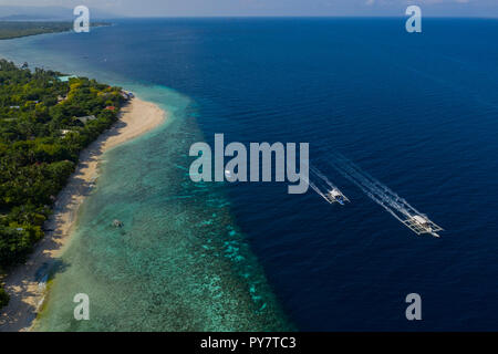 Côte le long de Moalboal, Cebu - plage connue sous le nom de White Beach avec Deux bateaux Bangka se dirigeant vers Scuba Diving loc Banque D'Images