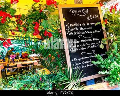 Tableau floral français menu du jour 'Menu du Chef' avec service à table derrière en français rustique typique restaurant à Concarneau Bretagne France Banque D'Images