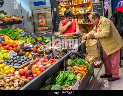 CONCARNEAU Fruit & Vegetable market stall avec jeunes adultes et de l'acheteur de payer pour produire des pièces en euros, Halles Concarneau Bretagne France Banque D'Images