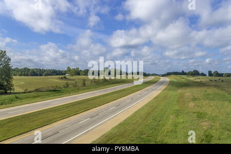 Route à quatre voies au soleil en milieu rural avec des nuages Banque D'Images