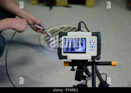 Man start à l'aide de camera d'inspection d'égout. Photo montrant le moniteur de la caméra de la tête qui est l'inspecteur holding. Banque D'Images