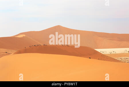 Désert de Namibie - touristes marcher la crête de dunes de sable dans le désert du Namib à Sossusvlei, Namibie, Afrique du Sud Banque D'Images