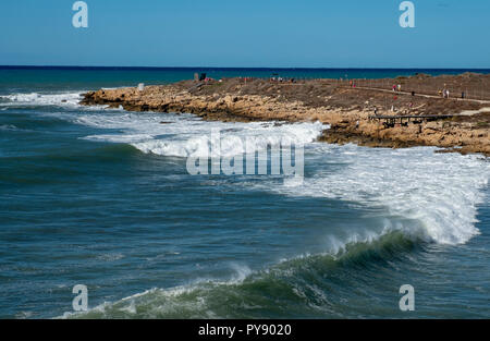 Les gens regardent comme de grandes vagues s'écraser sur le rivage près de château de Paphos, Paphos, Chypre Banque D'Images