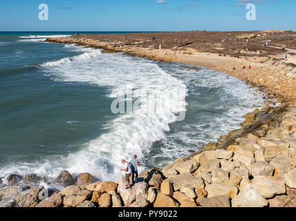 Les gens regardent comme de grandes vagues s'écraser sur le rivage près de château de Paphos, Paphos, Chypre Banque D'Images