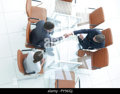 Poignée de l'autre côté de la table. Rencontre autour d'une table de conférence. Banque D'Images