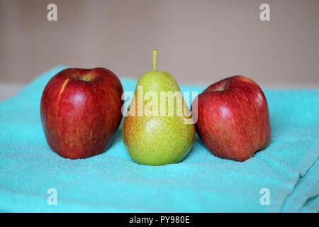 Deux pommes rouges et une poire Banque D'Images