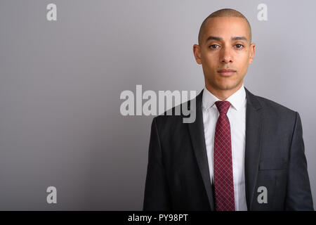 Handsome bald businessman wearing poursuite contre fond gris Banque D'Images