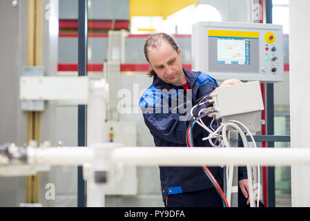 Employé d'usine l'utilisation d'une machine dans une usine Banque D'Images