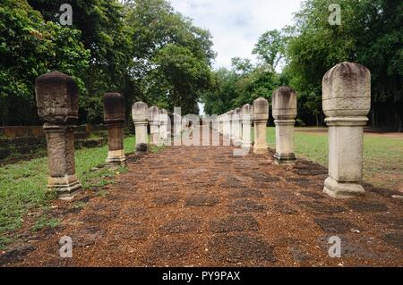 Allée pavée en pierre de latérite avec des postes en pierre aux portes de l'ancien temple Khmer Prasat Sdok Kok Thom dans Sa Kaeo province de Thaïlande Banque D'Images